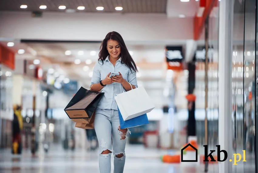 Kobieta w galerii handlowej z papierowymi torbami