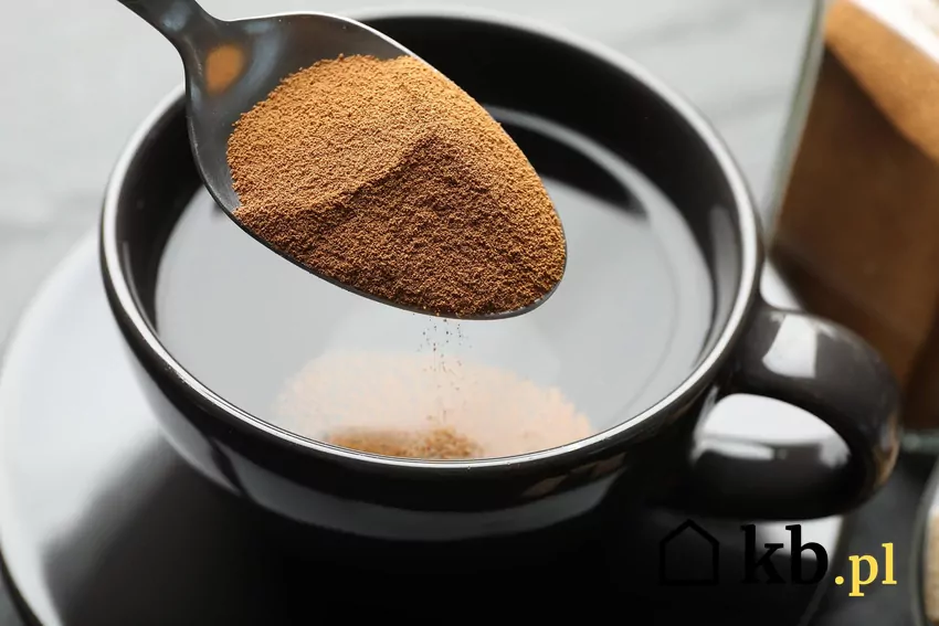 Kawa rozpuszczalna na łyżeczce nad szklanką