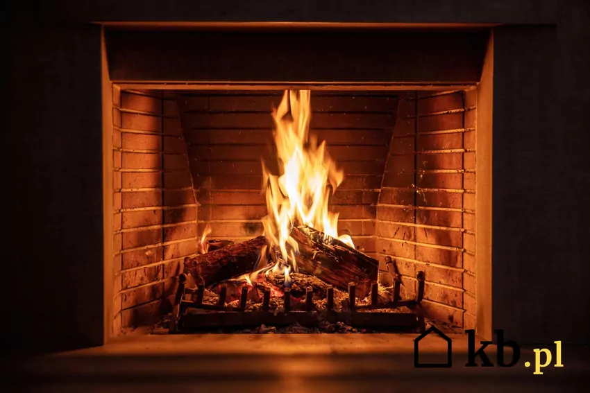Rozpalony kominek z polanami drewna