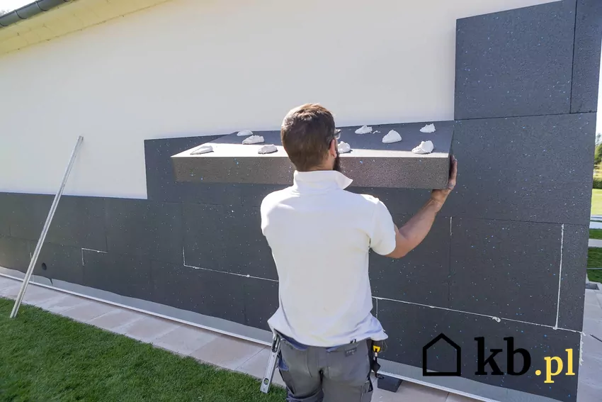 mężczyzna przykleja grafitowy styropian