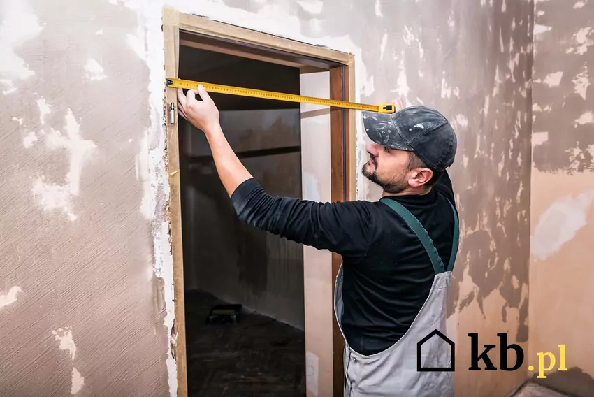 Mierzenie drzwi w domu oraz jak zmierzyć drzwi wewnętrzne krok po kroku Mężczyzna mierzący drzwi, a także jak zmierzyć drzwi w domu krok po kroku, najlepsze wskazówki
