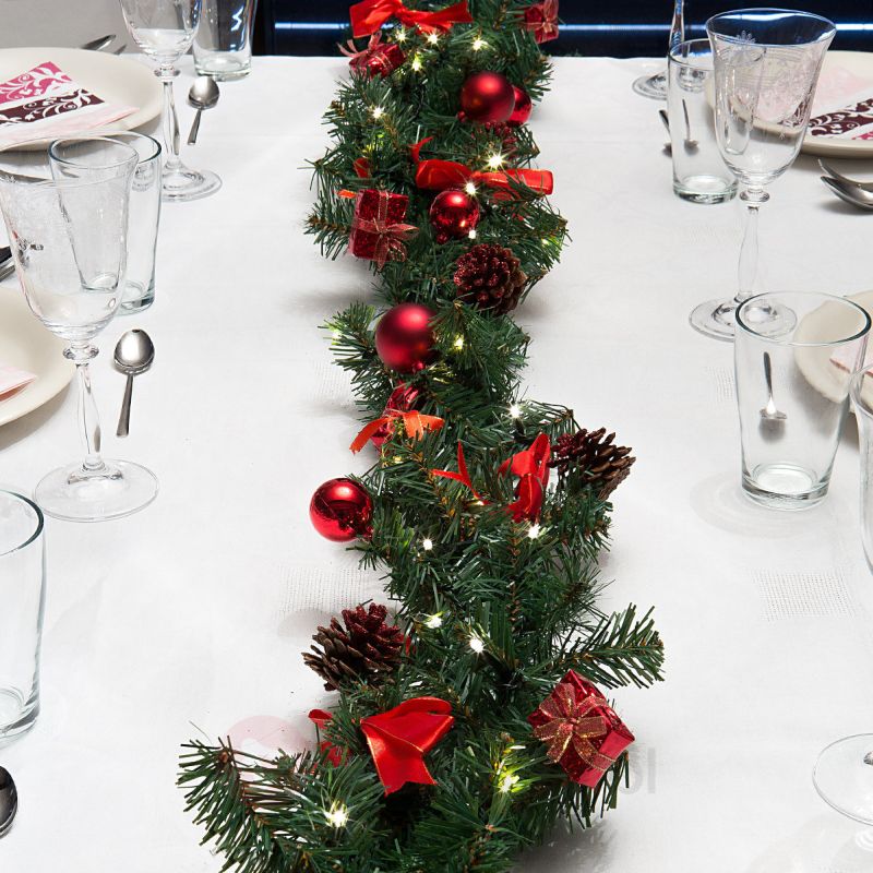 Stroik świąteczny z czerwonymi bąbkami na świątecznym stole