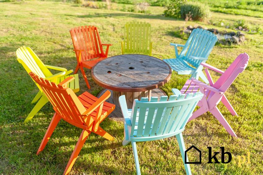 Kolorowe krzesła plastikowe wokół stołu jako meble ogrodowe dla osób ceniących tanie rozwiązania i najlepsze krzesła plastikowe