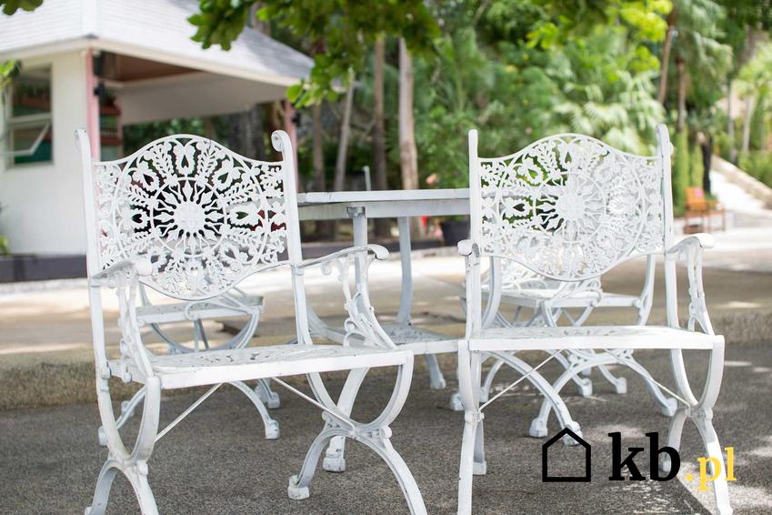 Meble ogrodowe aluminiowe, w których na pierwszy plan wysuwają się dwa białe krzesła aluminiowe oraz ich ceny i opinie