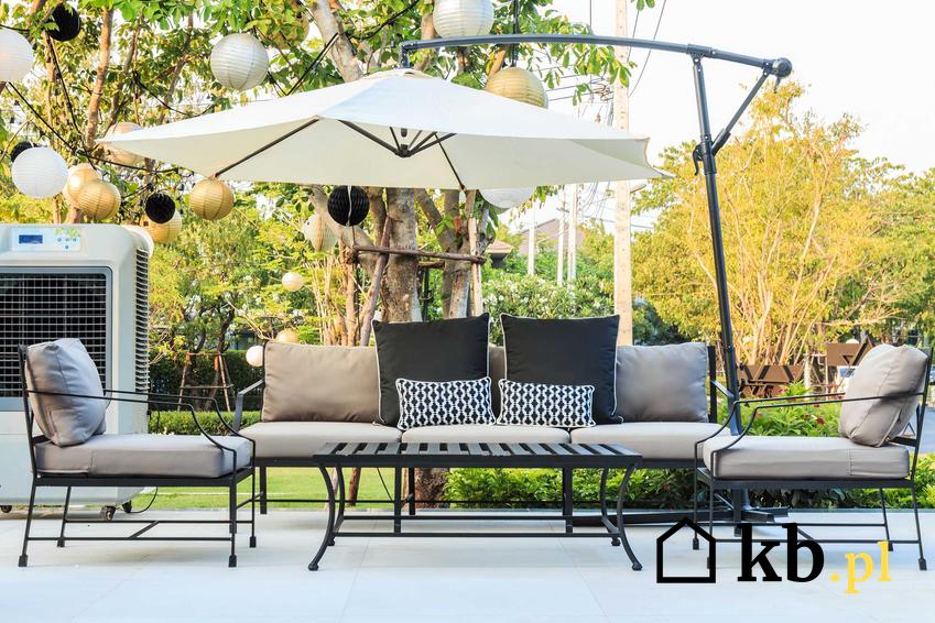 Nowoczesne meble ogrodowe, czyli nowoczesne krzesła i nowoczesne stoły z otwartym parasolem nad nimi