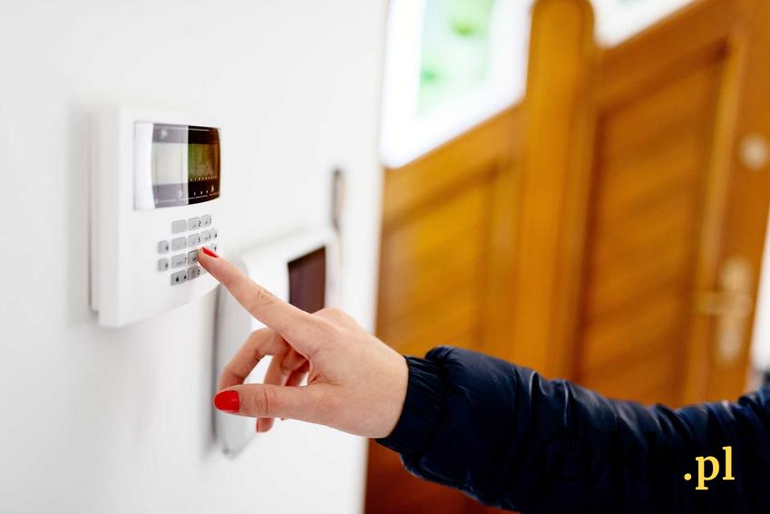 Alarm domowy obługiwany przez kobietę oraz polecane systemy alarmowe do domu oraz rodzaje alarmów do mieszkania