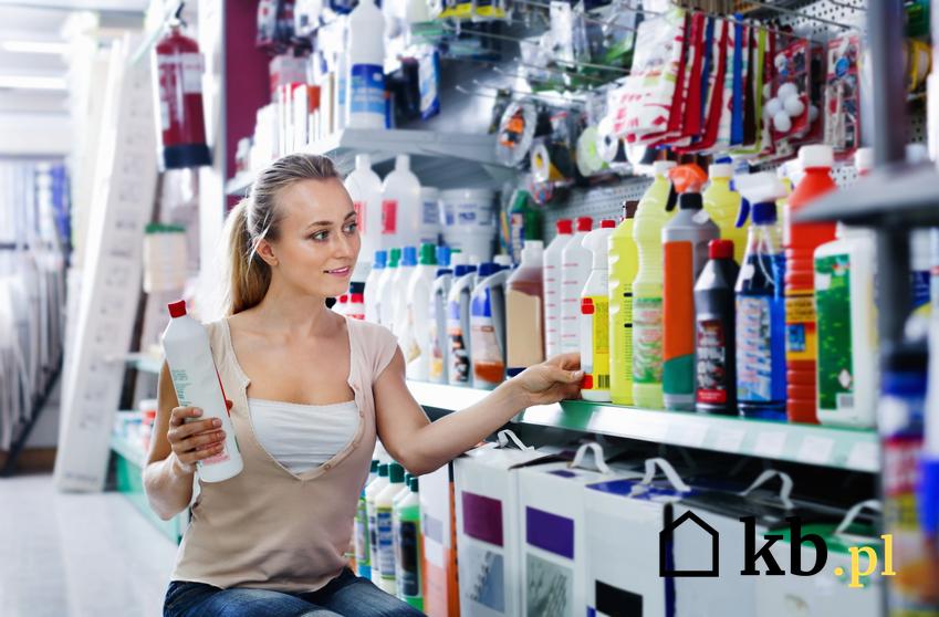 Kobieta oglądająca rozpuszczalniki na półce w sklepie, a także popularny rozpuszczalnik do farb