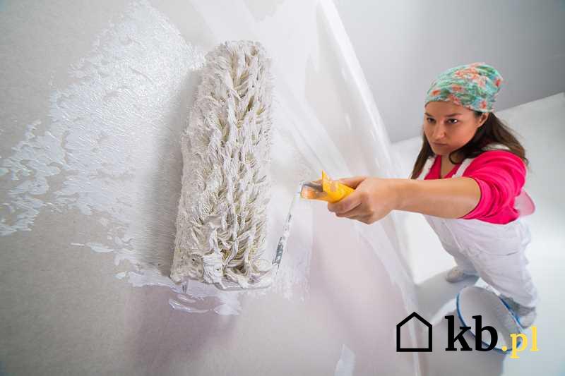 Kobieta malująca ściany w pokoju na biało wałkiem, czyli jak pomalować pokój lub całe mieszkanie krok po kroku