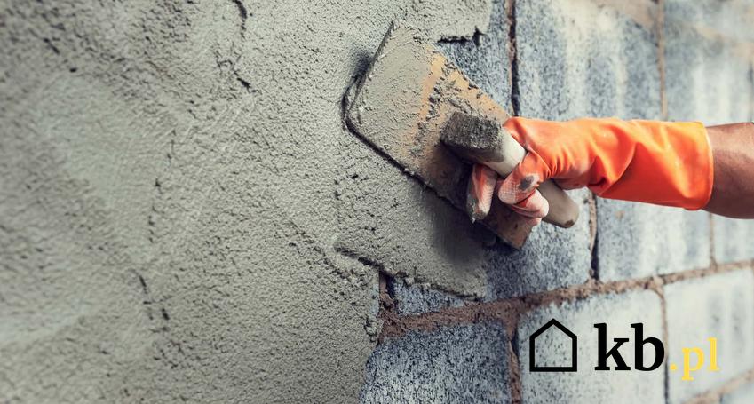 Robotnik nakłada beton na elewację, betonowa elewacja budynku, domieszki do betonu, jaka betoniarka jest najlepsza do mieszania cementu
