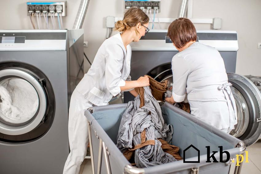 Kobiety w pralni wyjmują czyste pranie, jakie są polskie normy na temat zapewniania odzieży roboczej pracownikom