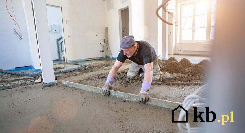 Mężczyzna wyrównuje wylewkę, robotnik na budowie poziomuje wylewkę, jak wykonać betonową podadzkę w domu, ile m3 betonu potrzeba do zrobienia wylewki