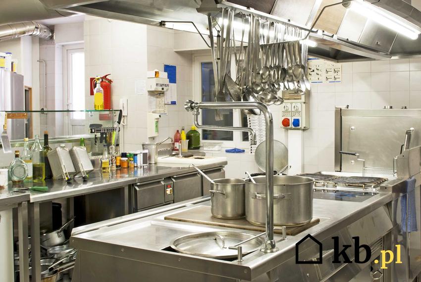 Kuchnia w restauracji czysta, urządzona w standardowy sposób nowymi meblami i sprzętami z aluminium i ze stali szlachetnej